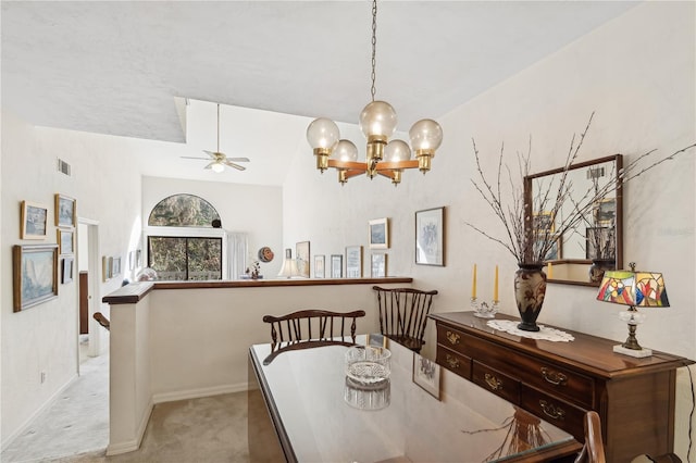 carpeted dining space with ceiling fan with notable chandelier and lofted ceiling