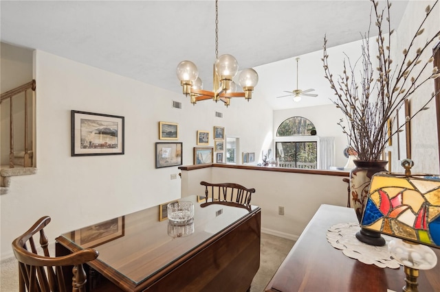 dining area with ceiling fan with notable chandelier, light carpet, and vaulted ceiling