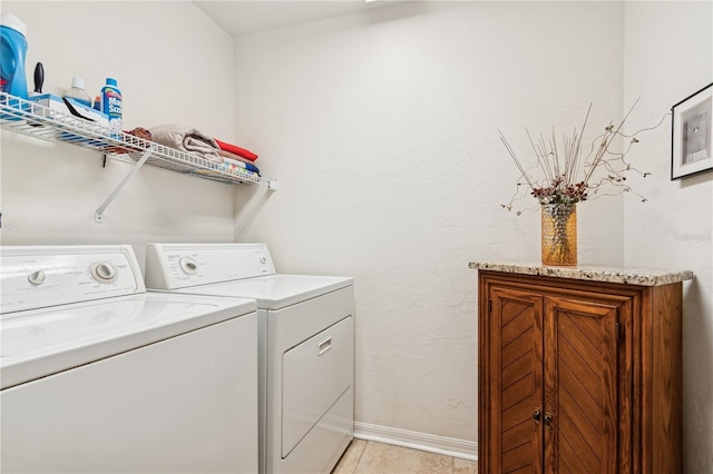 washroom with light tile patterned floors and washing machine and dryer