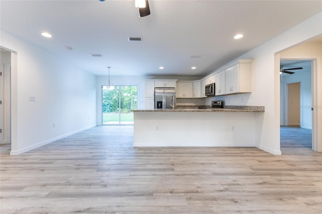 kitchen featuring white cabinets, stainless steel appliances, kitchen peninsula, and light hardwood / wood-style floors