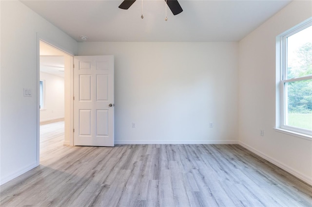 empty room with ceiling fan and light hardwood / wood-style floors