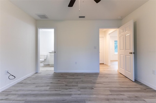 unfurnished bedroom with light wood-type flooring, ensuite bathroom, and ceiling fan