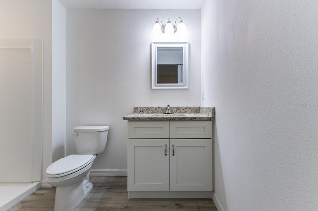 bathroom with vanity, toilet, and hardwood / wood-style flooring