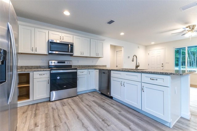 kitchen featuring sink, stainless steel appliances, white cabinetry, and stone countertops