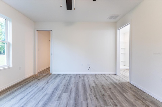 empty room with light wood-type flooring and ceiling fan