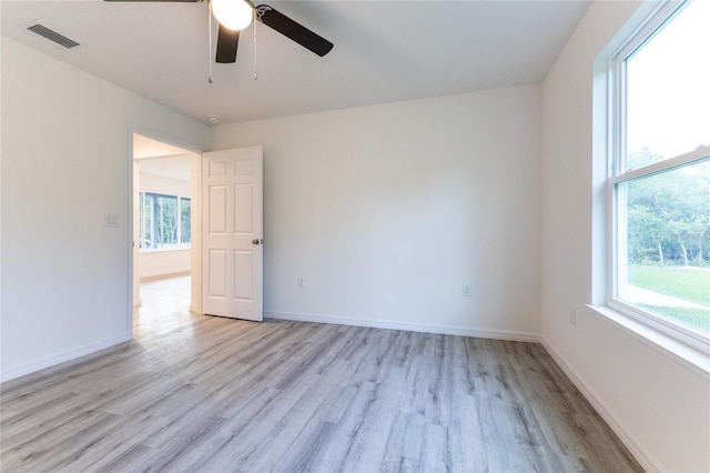 unfurnished room featuring ceiling fan, light wood-type flooring, and a wealth of natural light