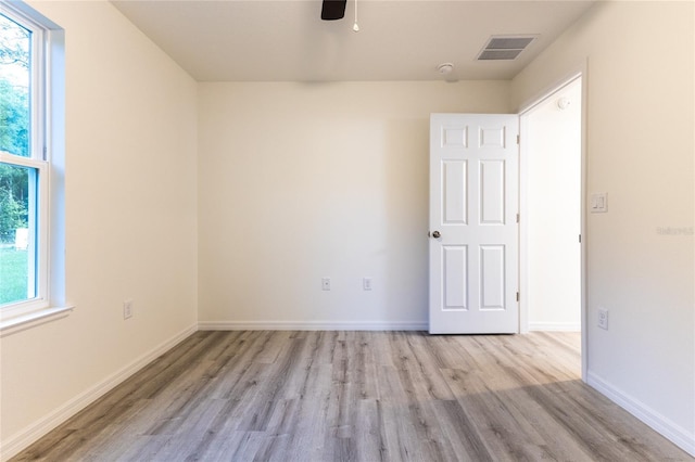 empty room with ceiling fan, light hardwood / wood-style flooring, and a wealth of natural light