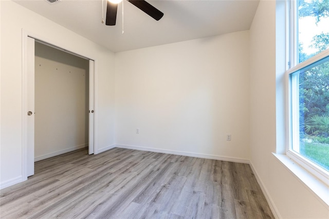 unfurnished bedroom with ceiling fan, a closet, and light wood-type flooring