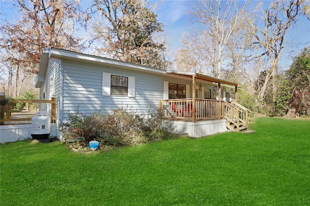 rear view of property featuring covered porch and a yard