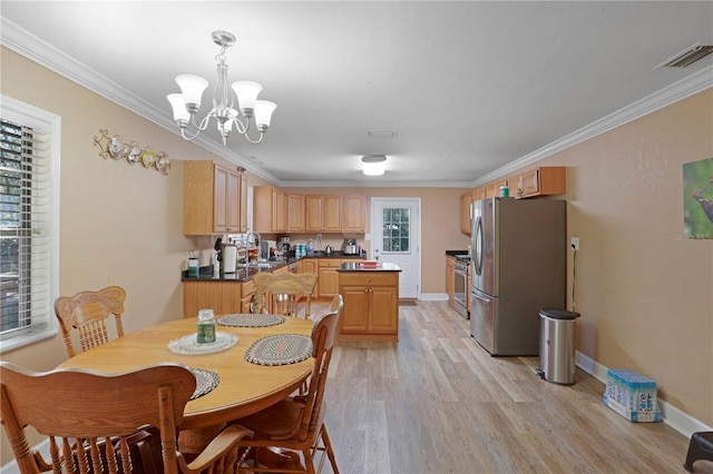 dining room with light wood-type flooring, ornamental molding, sink, and an inviting chandelier