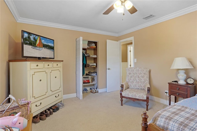 bedroom with ceiling fan, light colored carpet, crown molding, and a closet