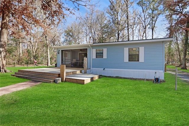 rear view of property with a lawn and a sunroom