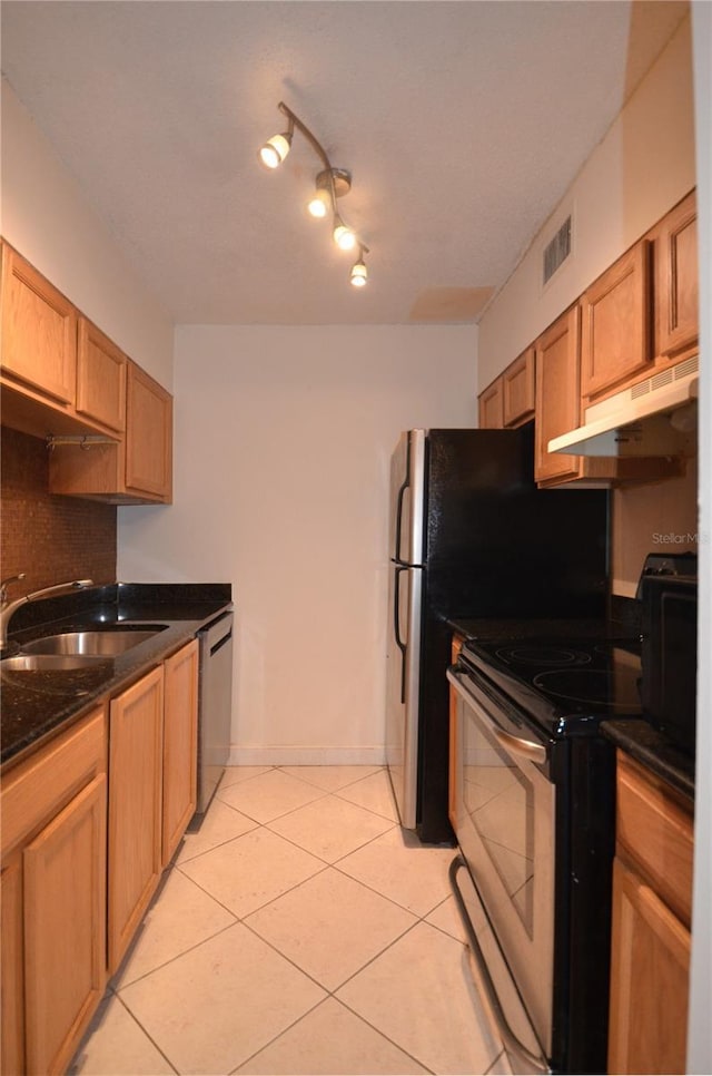 kitchen with dishwasher, sink, white range oven, dark stone counters, and light tile patterned floors