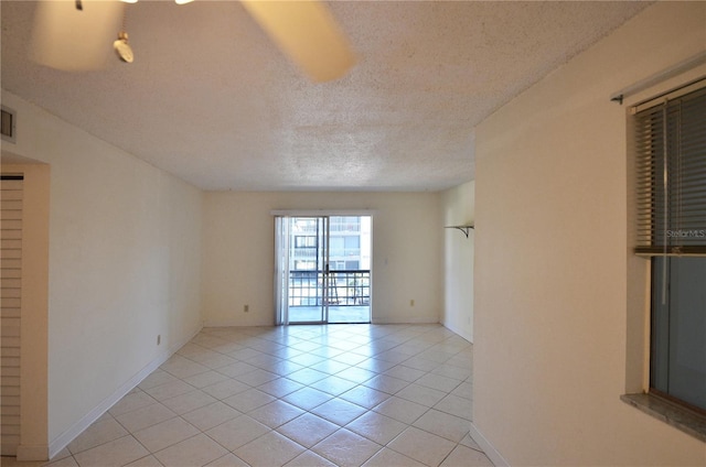 empty room featuring light tile patterned floors and a textured ceiling