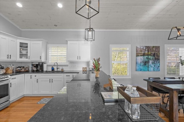 kitchen with white cabinets, pendant lighting, crown molding, and sink