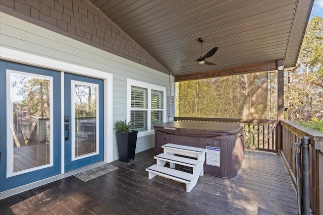 wooden deck with ceiling fan and a hot tub