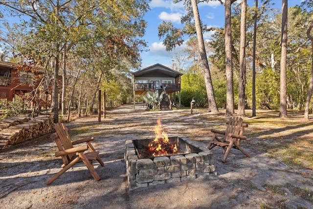 view of yard with a balcony and an outdoor fire pit