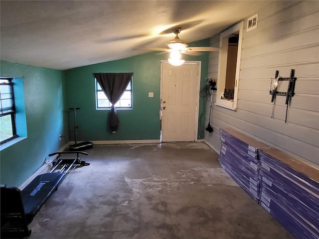 interior space featuring ceiling fan, vaulted ceiling, and concrete floors