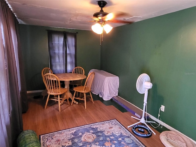 dining area with ceiling fan and wood-type flooring