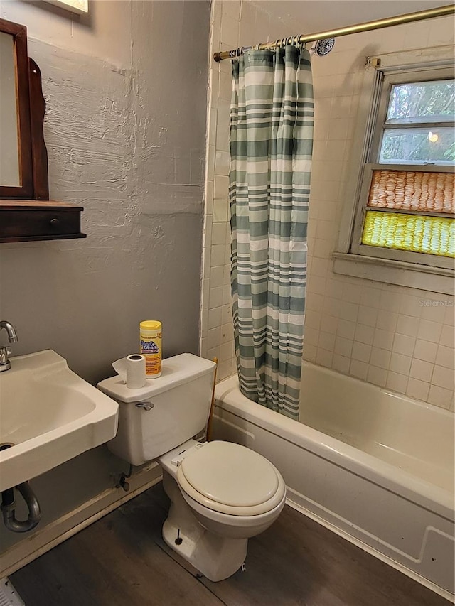 bathroom featuring hardwood / wood-style floors, toilet, and shower / bath combo with shower curtain