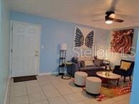 living room with tile patterned floors and ceiling fan