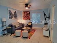 tiled living room featuring ceiling fan