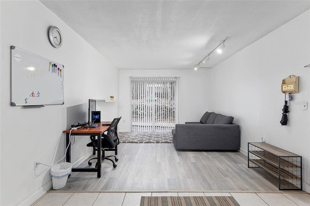 home office featuring rail lighting, light tile patterned flooring, and a textured ceiling