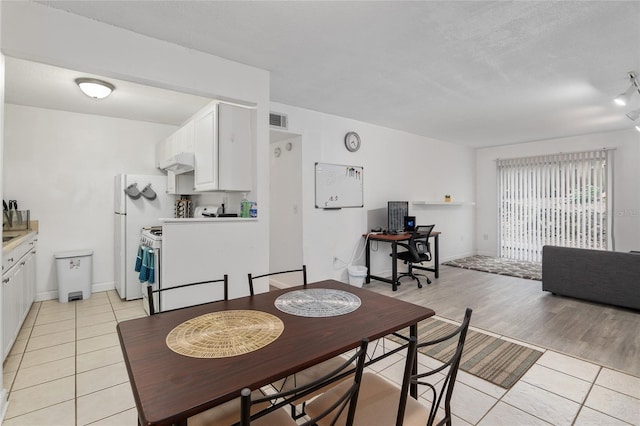 dining space featuring light tile patterned floors and a textured ceiling