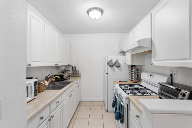 kitchen featuring white appliances, sink, a textured ceiling, light tile patterned flooring, and white cabinetry