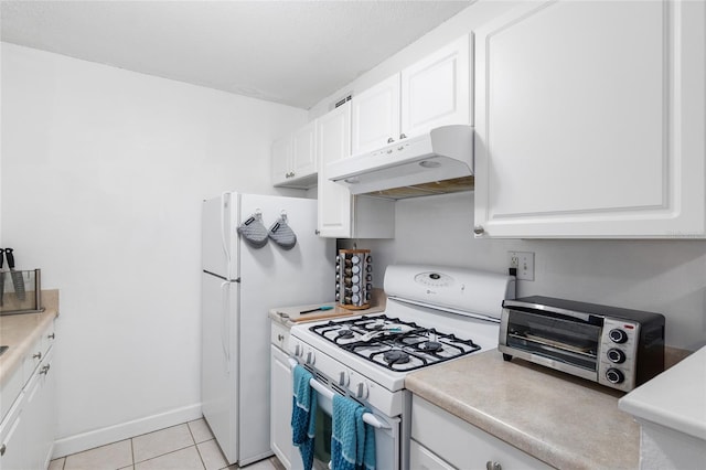 kitchen featuring light tile patterned floors, white cabinets, and white appliances