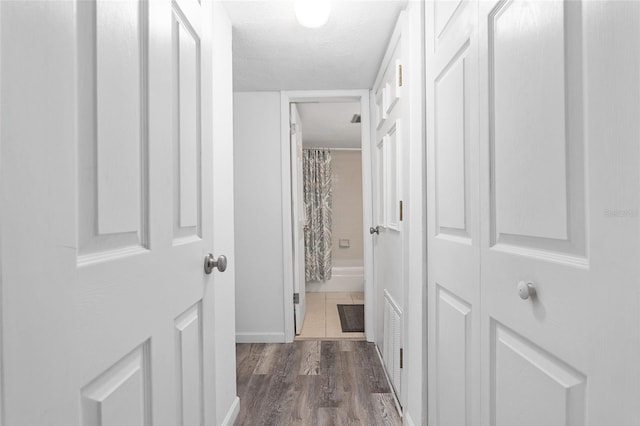 hallway with dark hardwood / wood-style flooring and a textured ceiling