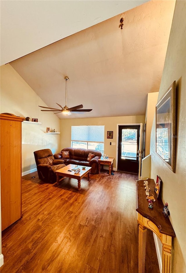 living room with ceiling fan, vaulted ceiling, and wood-type flooring