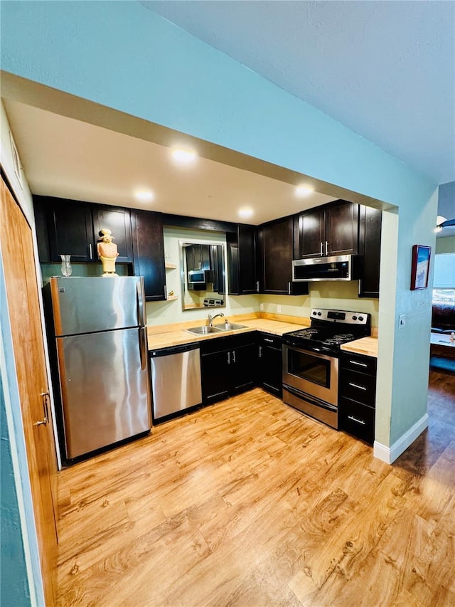 kitchen featuring sink, ventilation hood, stainless steel appliances, and light hardwood / wood-style floors