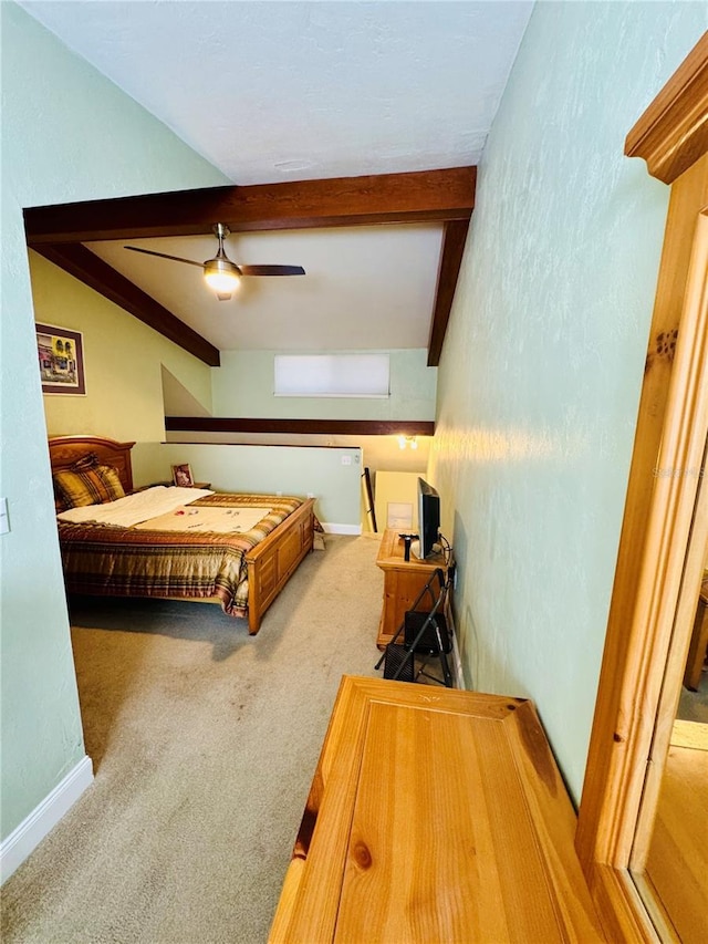 carpeted bedroom featuring beamed ceiling and ceiling fan