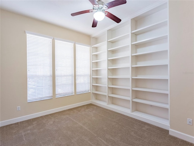 carpeted empty room with ceiling fan and built in features