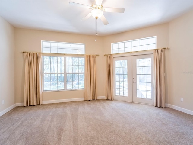 empty room featuring ceiling fan, light carpet, and french doors