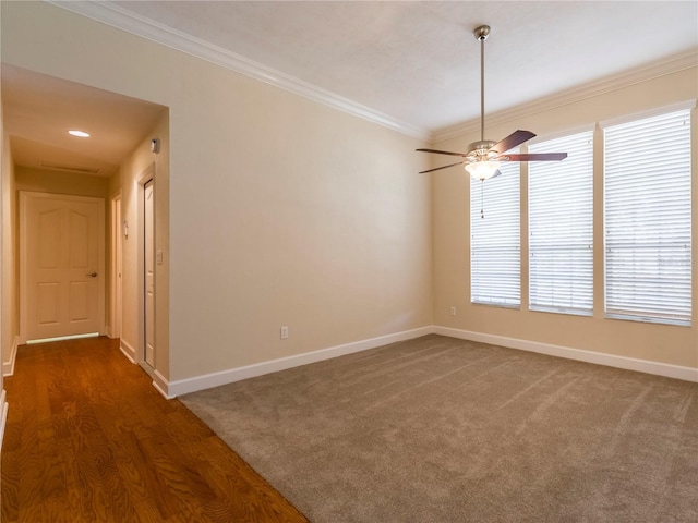 spare room featuring ceiling fan, crown molding, and dark carpet