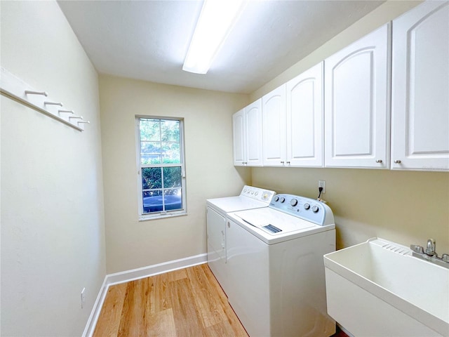 8305 SW 16th Pl, Gainesville, FL 32607 - laundry room with cabinet space, washer and clothes dryer, light wood-type flooring, and baseboards