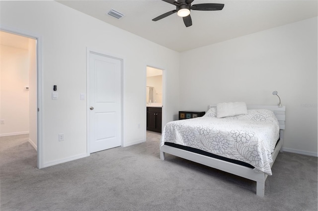 bedroom featuring connected bathroom, light colored carpet, and ceiling fan