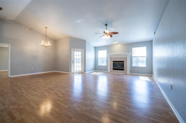 unfurnished living room with lofted ceiling, hardwood / wood-style floors, and ceiling fan with notable chandelier