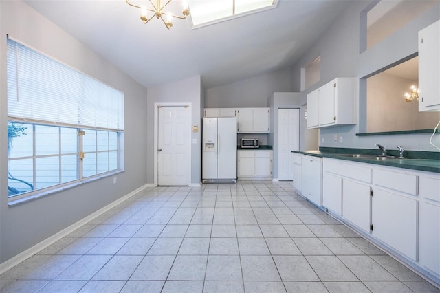 kitchen with white appliances, sink, vaulted ceiling, a notable chandelier, and white cabinetry