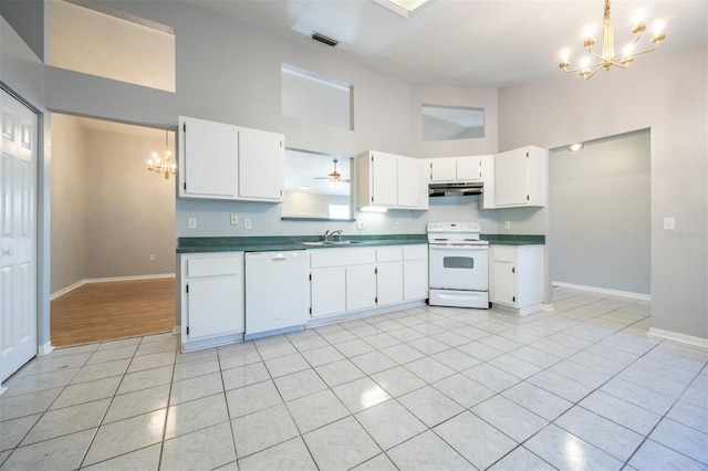 kitchen with white cabinetry, light tile patterned floors, a high ceiling, and white appliances