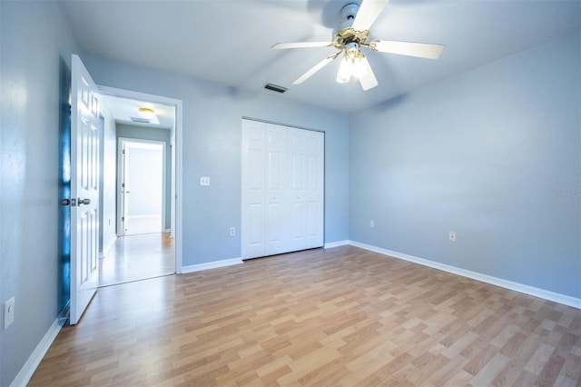 unfurnished bedroom featuring ceiling fan, light wood-type flooring, and a closet