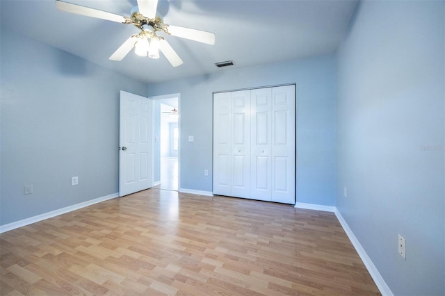 unfurnished bedroom featuring light wood-type flooring, a closet, and ceiling fan