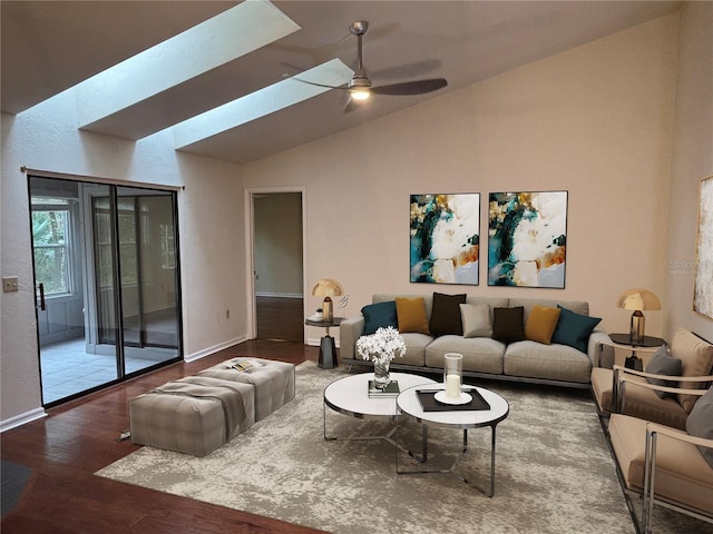 living room with ceiling fan, vaulted ceiling with skylight, and hardwood / wood-style floors