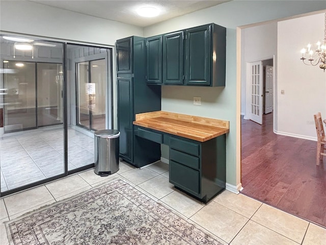 kitchen featuring butcher block countertops, light tile patterned flooring, and an inviting chandelier