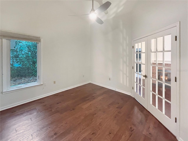 empty room featuring ceiling fan, french doors, and dark wood-type flooring