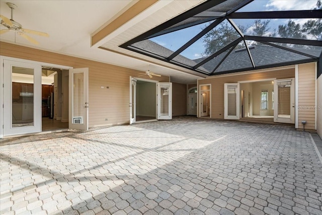 unfurnished sunroom with lofted ceiling with skylight and ceiling fan