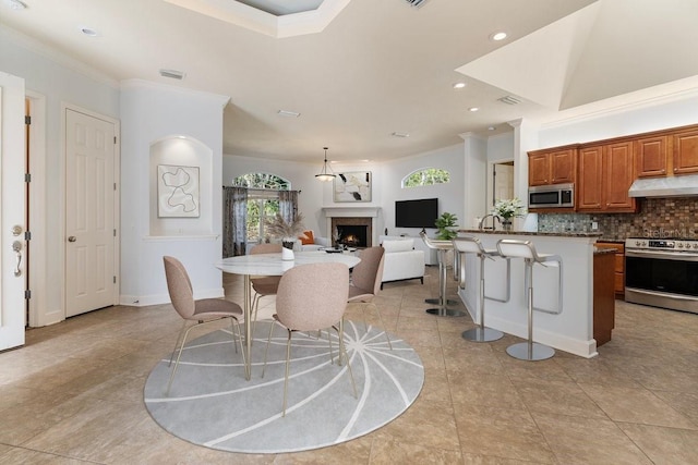 dining area featuring ornamental molding and light tile patterned flooring