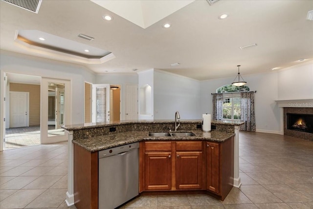 kitchen featuring stainless steel dishwasher, dark stone counters, a kitchen island with sink, and sink